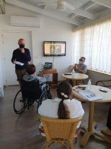 Meeting room with elderly people looking at illustrations of smartphone screens.